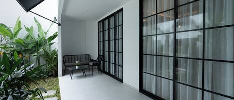 A modern interior with a seating area, large windows, and indoor plants.