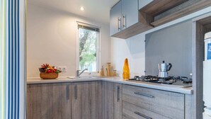 Eine moderne Küche mit Holzausstattung, einem Gasherd und einem Fenster für natürliches Licht.