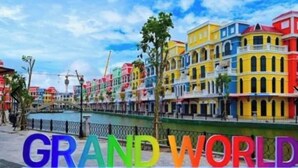 Värikkäitä rakennuksia, joiden edessä on kyltti, jossa lukee: ”GRAND WORLD”.