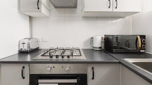 Eine moderne Küche mit Gasherd, Toaster, Mikrowelle und Kaffeemaschine.