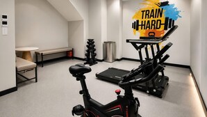A home gym with an exercise bike, treadmill, and dumbbells. - Sevendays Hotel (My Hanh)