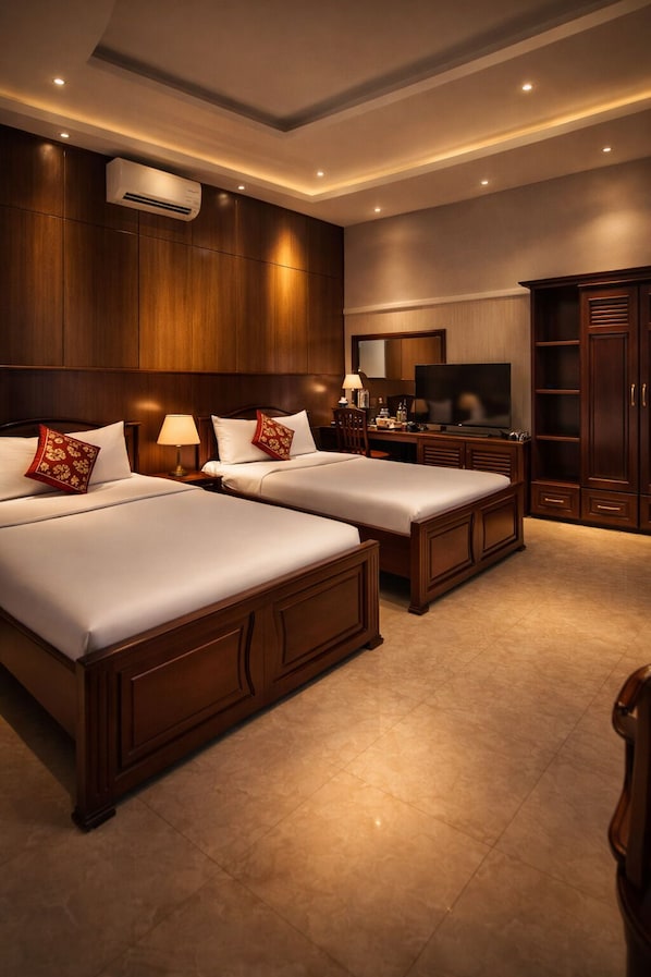 A hotel room with two beds, a TV, a desk, and a wardrobe. - Seven Days Hotel (Duc Hoa)