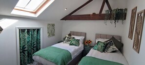Ein Schlafzimmer mit zwei Betten, einem Oberlicht und Blick ins Freie.