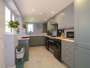 A modern kitchen with grey cabinets, a built-in oven, and a dishwasher.