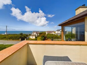 A balcony with a view of houses and the sea. - Swyn Llyr, Rhosneigr, Anglesey (Rhosneigr)