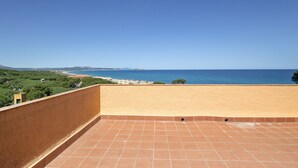Une terrasse avec vue sur la mer et la verdure.