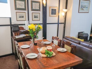 A dining table set with plates, wine glasses, and a bouquet of flowers. - Steps Cottage, North Yorkshire (Whitby)