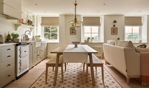 Una cocina con mesa de comedor, sofá y vistas al exterior.