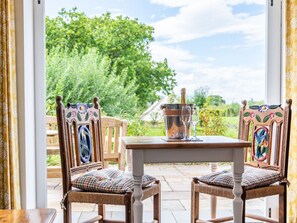 A patio with two wicker chairs, a table, and a bottle of champagne. - The Lodge, Chester: Cozy Retreat (Chester)