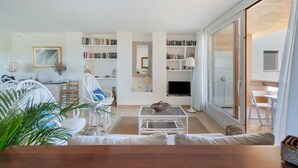 Un salon moderne avec un canapé, une table basse et une bibliothèque.