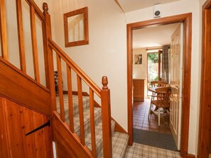 Eine Holztreppe führt zu einem Essbereich mit Tisch und Stühlen.