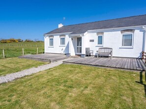 A white house with a wooden deck, a gravel path, and a grassy yard. - Happy Daze, Morfa Nefyn (Pwllheli)