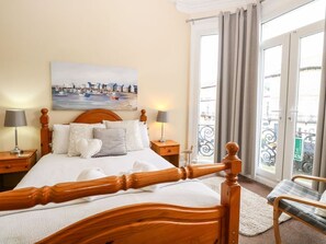 Hotelkamer met een bed, twee nachtkastjes, een stoel, een schilderij en uitzicht.