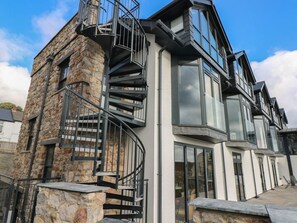 A modern building with a stone facade, large windows, and a spiral staircase. - 11 Brython Place, Tenby (Tenby)
