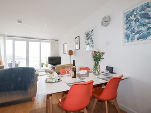 A modern living room with a dining area, large windows, and artwork on the walls. - BUENA VISTA: Coastal Retreat (Newquay)