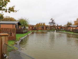 Un vecindario con casas, un estanque y una cerca de madera.