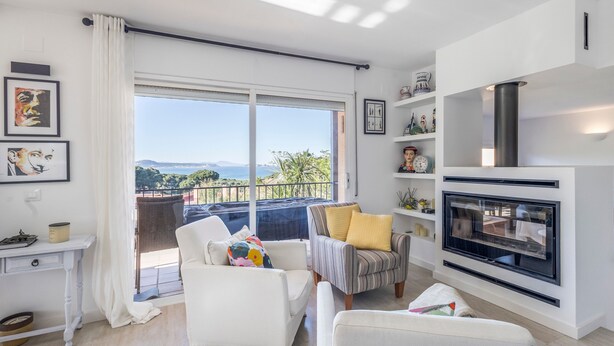 Un salon moderne avec balcon, des meubles blancs et une cheminée.
