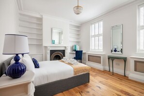 A bedroom with a bed, bedside table, lamp, fireplace, and a mirror. - 32 Park Street, Windsor, Berkshire (Windsor)