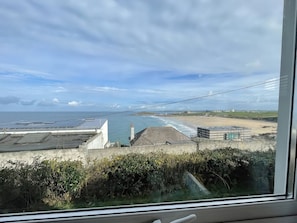 A coastal view with buildings, a beach, and a clear sky. - 38 Surf View, Newquay (Newquay)