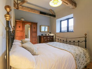 Un dormitorio con cama, armario de madera y ventana.