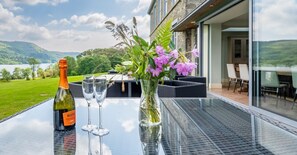 Ein Tisch mit einer Weinflasche, zwei Gläsern und einer Blumenvase.