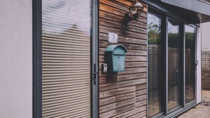 Ein Briefkasten, eine Tür und ein Fenster an einem Gebäude.