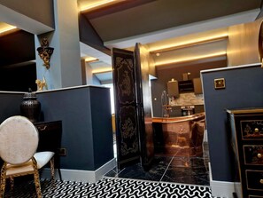 A modern interior with a black and white patterned floor, a gold chair, and a dark blue wall with a decorative panel.