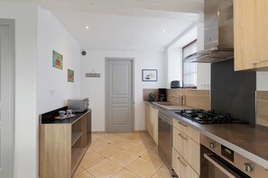 A compact kitchen with a microwave, toaster, and gas stove.