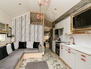 A modern kitchen with white cabinets, a wooden countertop, and a built-in oven.