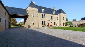 A stone building with a gravel driveway and a covered entrance.