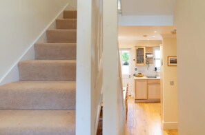 A staircase leading to a kitchen with wooden cabinets and a window. - 17 Solent Landing, Bembridge (Bembridge)