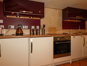 A kitchen with a stove, oven, and a kettle on the countertop. - The Cave in Newquay, Cornwall. (Newquay)