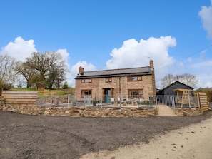 A two-story stone house with a fenced yard, a small shed, and a clear sky. - Aelybryn in Nantmawr, Trefonen (Oswestry)