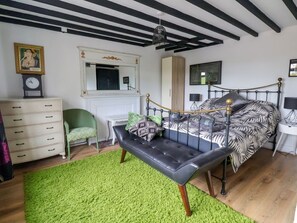 A bedroom with a bed, a bench, a dresser, a mirror, and a clock. - Aelybryn in Nantmawr, Trefonen (Oswestry)