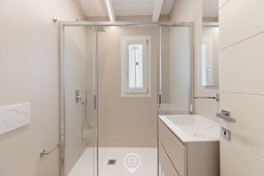 Een douche, een bidet, handdoeken, shampoo