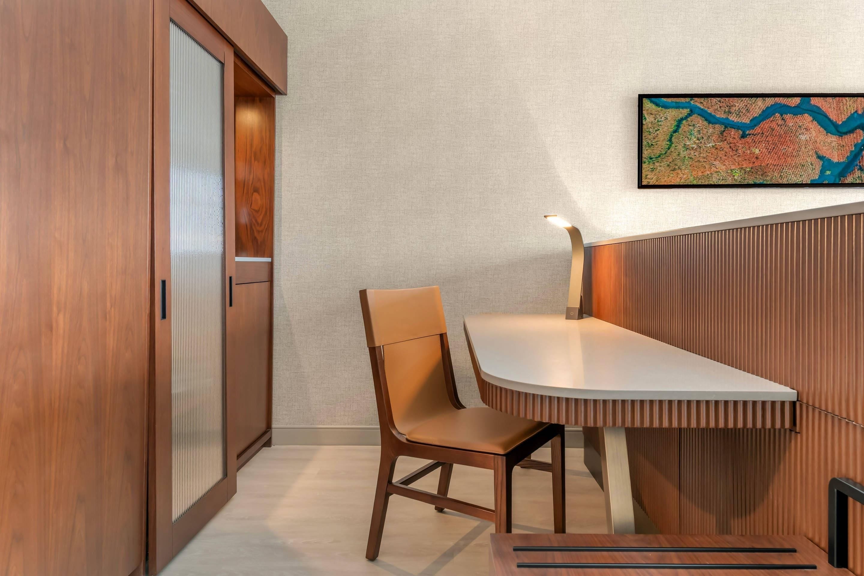 Un interior moderno con un mueble de madera, una silla, una mesa y un mapa en la pared.