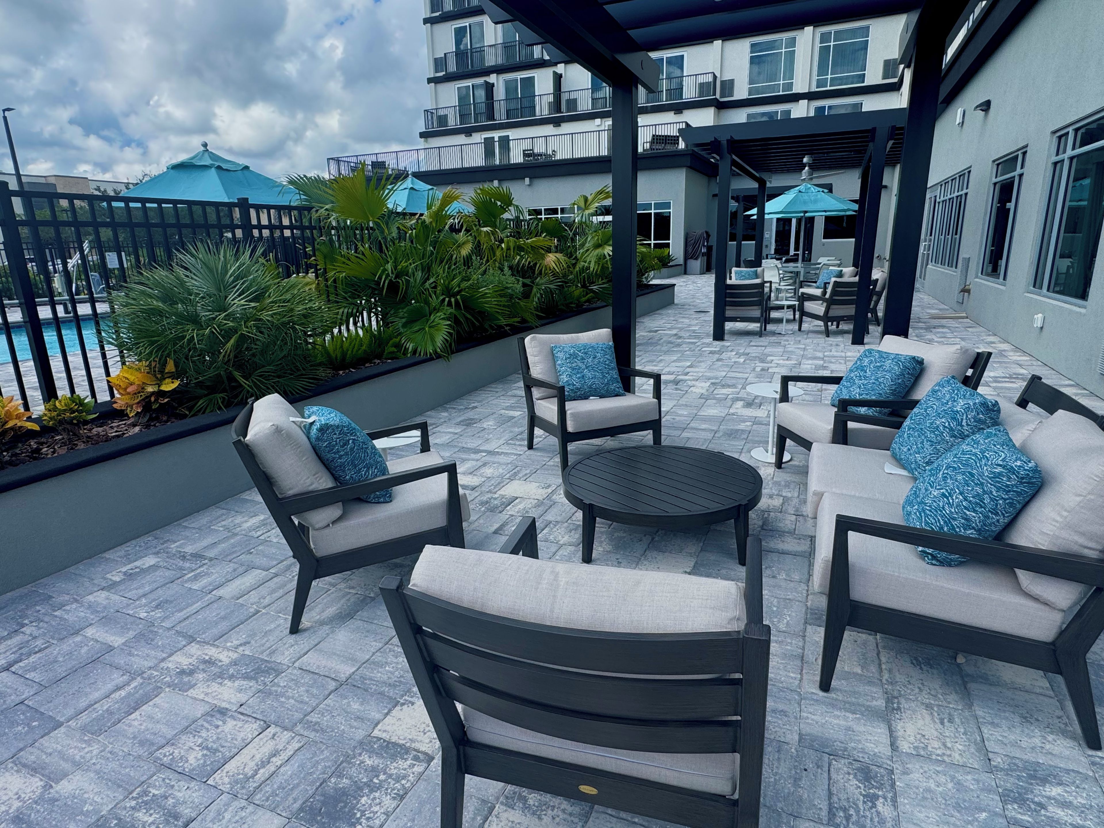 An outdoor patio with seating and a pool view.
