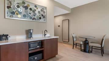 A modern kitchen with a built-in microwave, coffee maker, and a large decorative mirror.