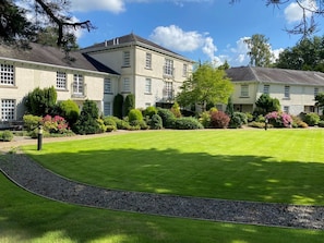 A large, two-story building with a well-maintained lawn and a gravel path. - Lakeside View, Windermere Lake (Ulverston)