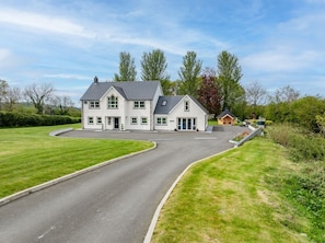 Une maison à deux étages avec une allée menant à la porte d’entrée.