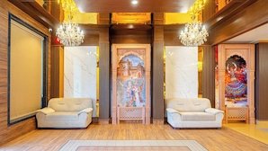 A lobby with two sofas, a patterned rug, and a decorative wall with a mural.
