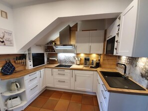 Fridge, microwave, oven, stovetop - House Süüderwoi - apartment 3 - ground floor - vacation apartment in Borgsum: terrace, garden, (Borgsum)