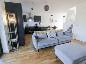 Ein modernes Wohnzimmer mit einem grauen Sofa, einem Couchtisch und einem Bücherregal.