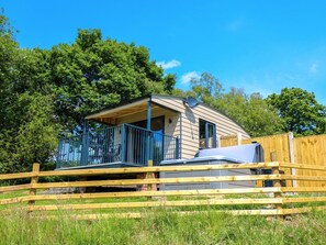 Una casa mobile con un cortile recintato, un'antenna parabolica e un barbecue.