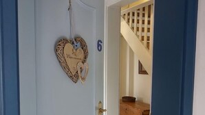 Uma porta azul com um detalhe em formato de coração e o número 6.