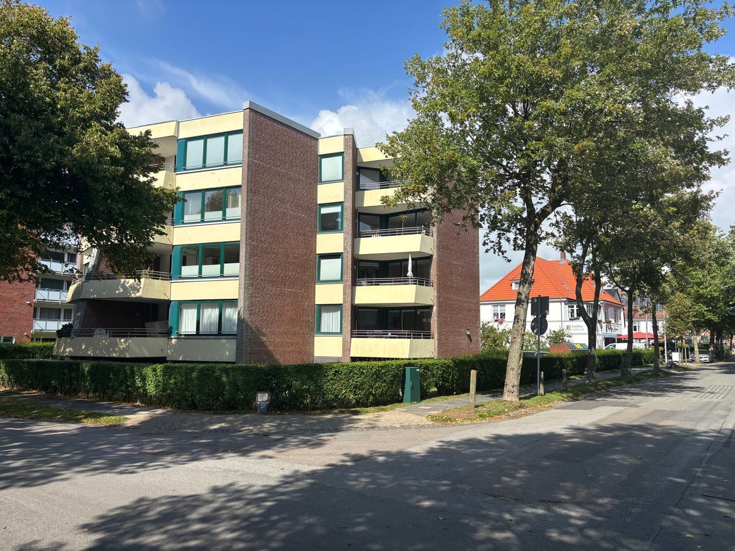 Ein mehrgeschossiges Gebäude mit flachem Dach, großen Fenstern und einer Ziegel-Fassade.