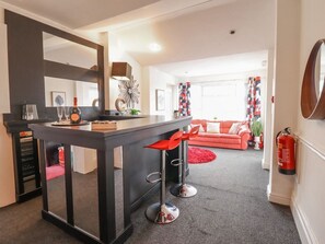 Eine moderne Küche mit Barbereich, einem roten Sofa und einem Feuerlöscher.