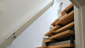 A staircase with wooden steps and a white wall. - Pastoratshof - House 6 - 5-star vacation home Pastoratshof - House 6 with sauna & sauna facilities (Wrixum auf Föhr)