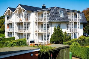A multi-story building with balconies, a flat roof, and a garden area. - Palais am Südstrand - Whg. 1 - Apartment Palais am Südstrand: Sauna, (Wyk auf Föhr)