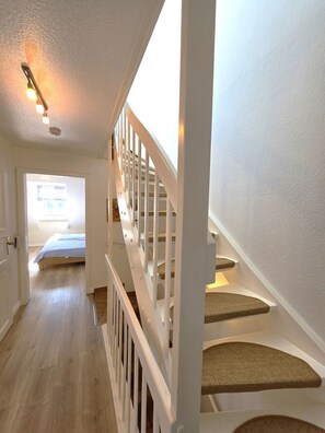 A staircase with white railings and a landing with a cushioned seat. - Eulenkamp 8 a - DHH left - Holiday home Eulenkamp 8a: DHH left, 200 m to the beach (Wyk auf Föhr)